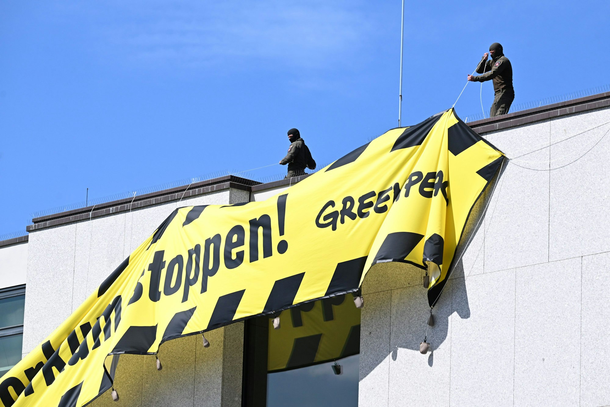 Mitglieder einer Einheit des SEK der Polizei stehen auf dem Dach des niedersächsischen Landtags und entfernen ein Transparent von Greenpeace gegen eine Gasbohrung vor der Nordseeinsel Borkum.