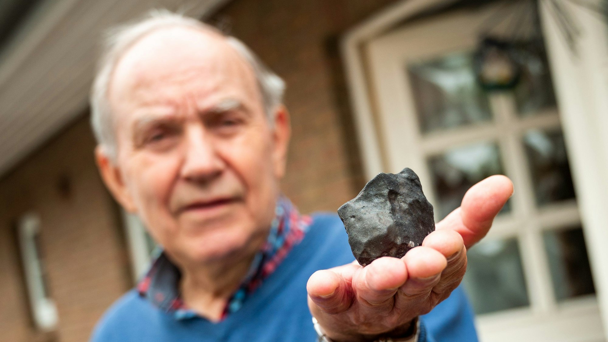 Wilfried Labusch, Hausbesitzer, hält vor seinem Haus einen kleinen Meteoriten, der niedergegangen ist. Der Gesteinsbrocken von der Größe eines Tennisballs habe das Dach eines Hauses durchschlagen, dem Deutschen Zentrum für Luft- und Raumfahrt zufolge ist ein solches Ereignis sehr selten.