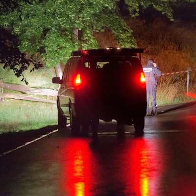 Polizei steht vor einem abgesperrten Gelände an einem Bauernhof.