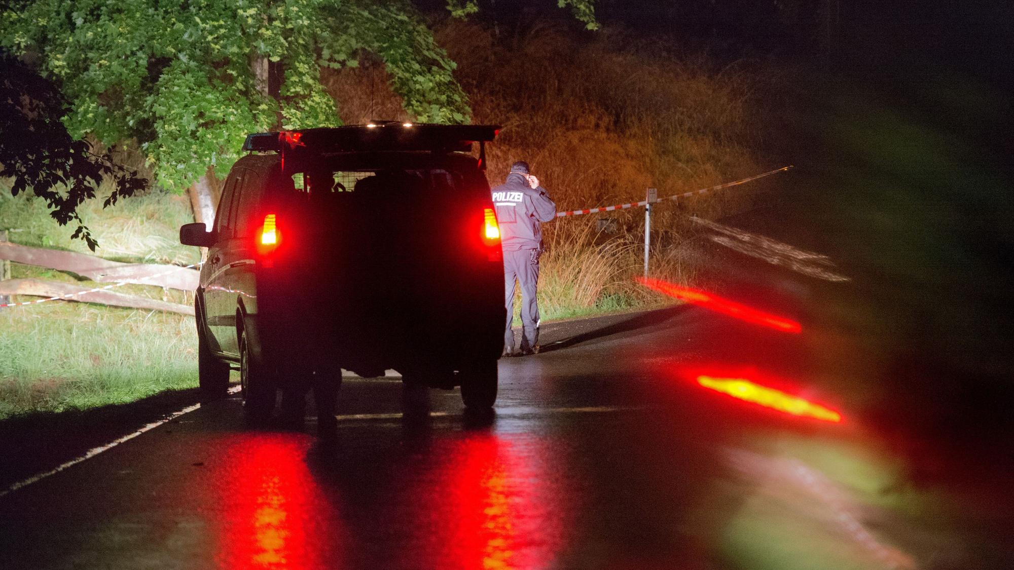 Polizei steht vor einem abgesperrten Gelände an einem Bauernhof.