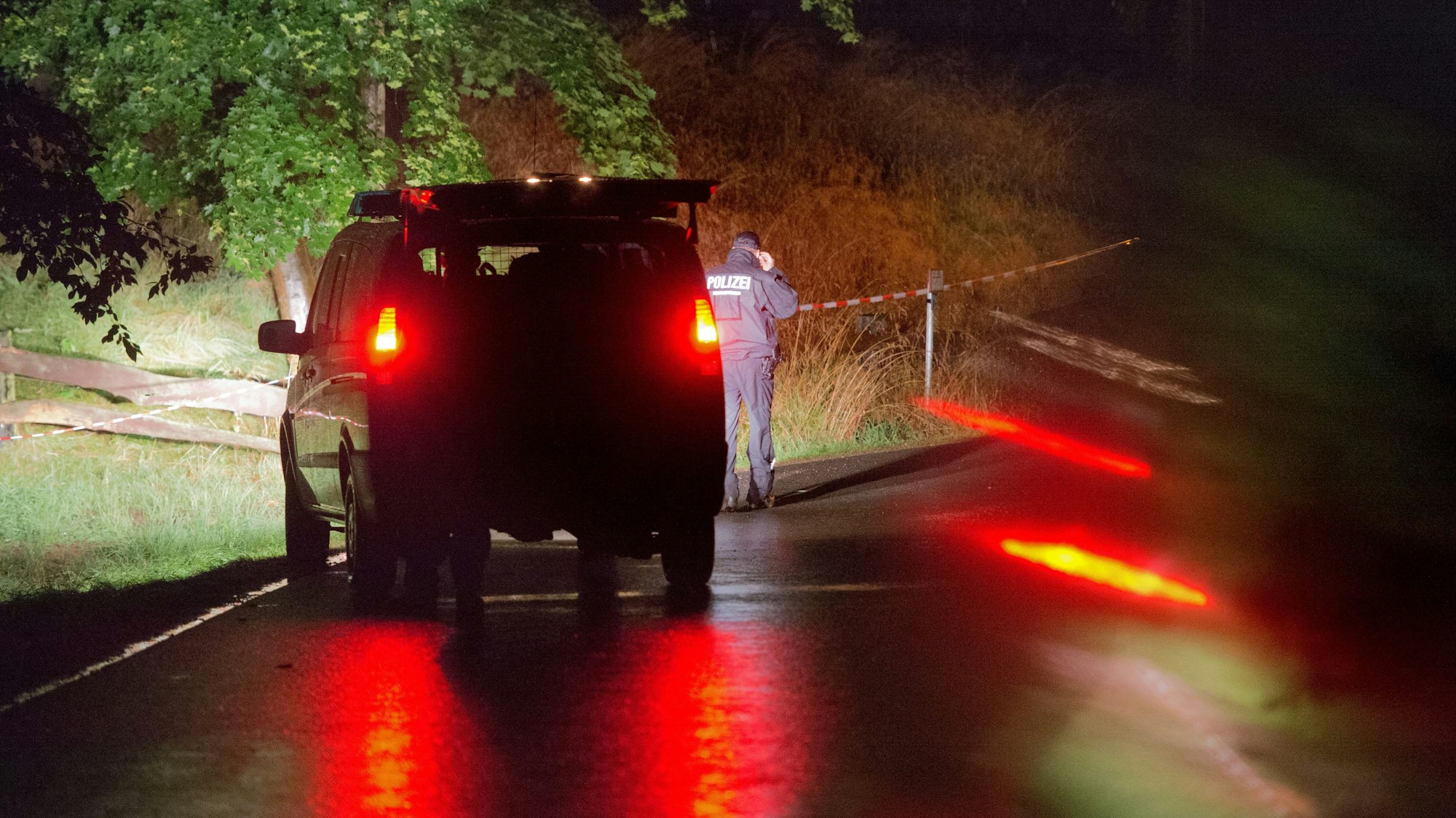 Polizei steht vor einem abgesperrten Gelände an einem Bauernhof.