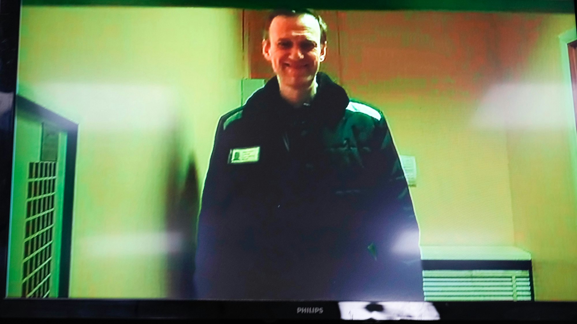 Alexej Nawalny, Kremlkritiker aus Russland, ist per Videolink bei einer Anhörung auf einem Monitor im Moskauer Bezirksgericht Babushkinsky zu sehen. Er lächelt.