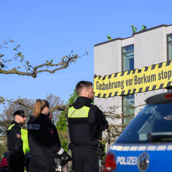 Polizisten beobachten, wie Aktivisten der Umweltschutzorganisation Greenpeace am frühen Morgen Banner an der Fassade des niedersächsischen Landtages befestigen. Greenpeace protestiert gegen eine Gasbohrung vor der Nordseeinsel Borkum.