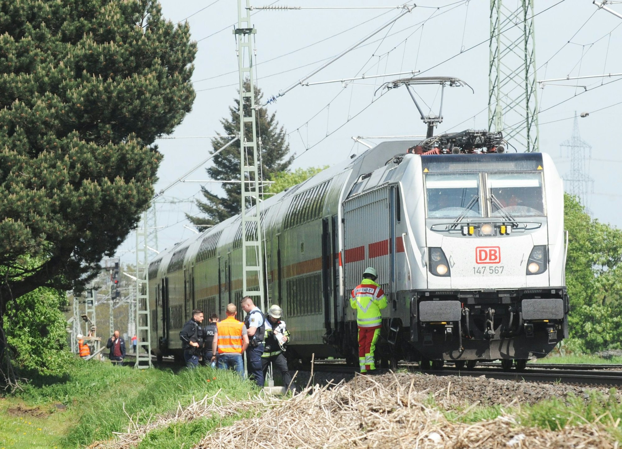 Das Bild zeigt einen stehen Zug und Mitarbeiter des Rettungsdienstes.