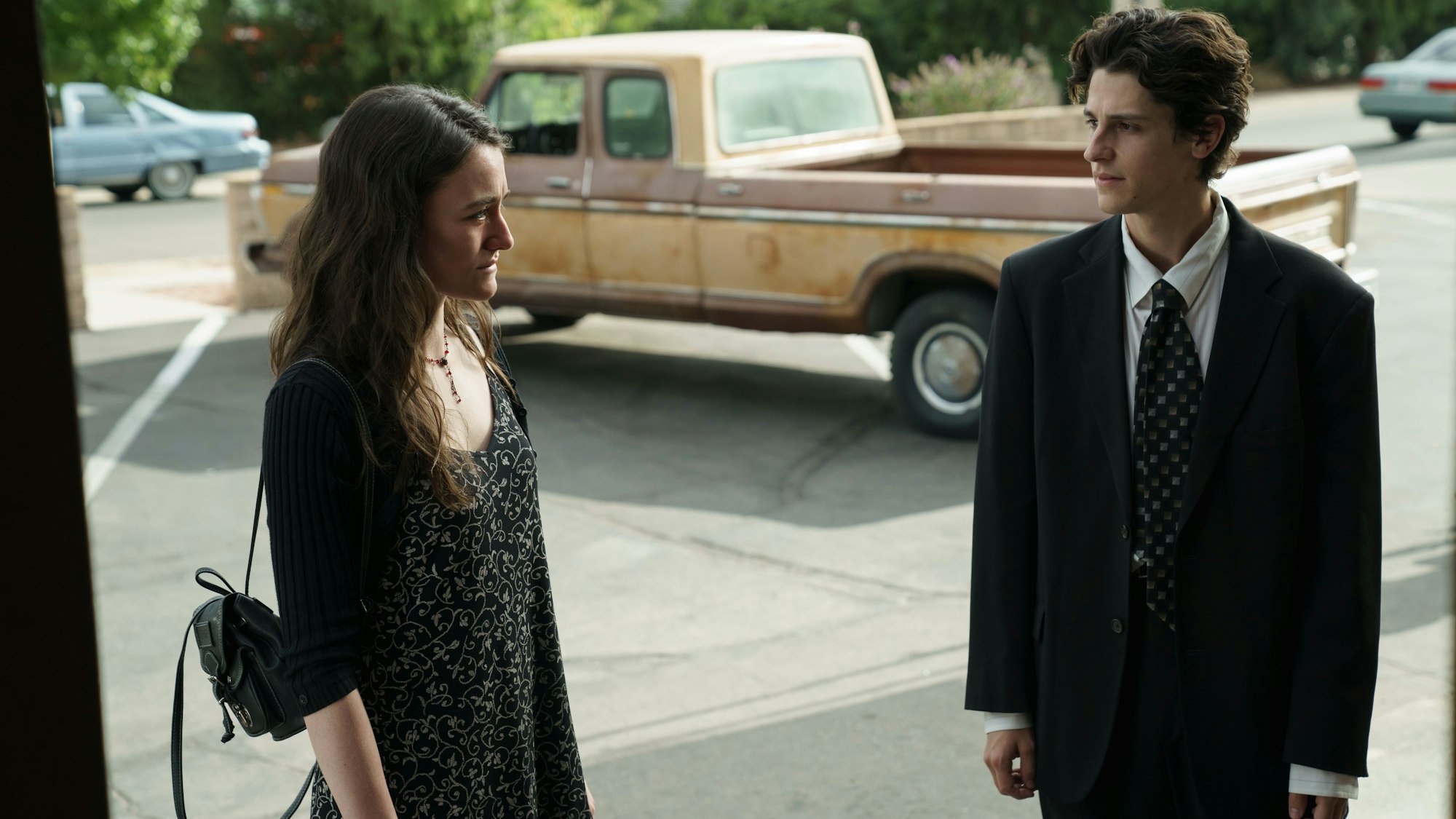 Eine junge Frau und ein junger Mann stehen im Sonnenlicht.