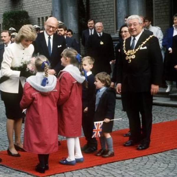 Der britische Kronprinz Charles (l) und seine Gattin Prinzessin Diana am 03.11.1987 in Köln. Während der Kronprinz sich umschaut und nach oben blickt, überreichen Kinder seiner Ehefrau Blumen. Rechts im Bild: Norbert Burger, damaliger Oberbürgermeister von Köln.