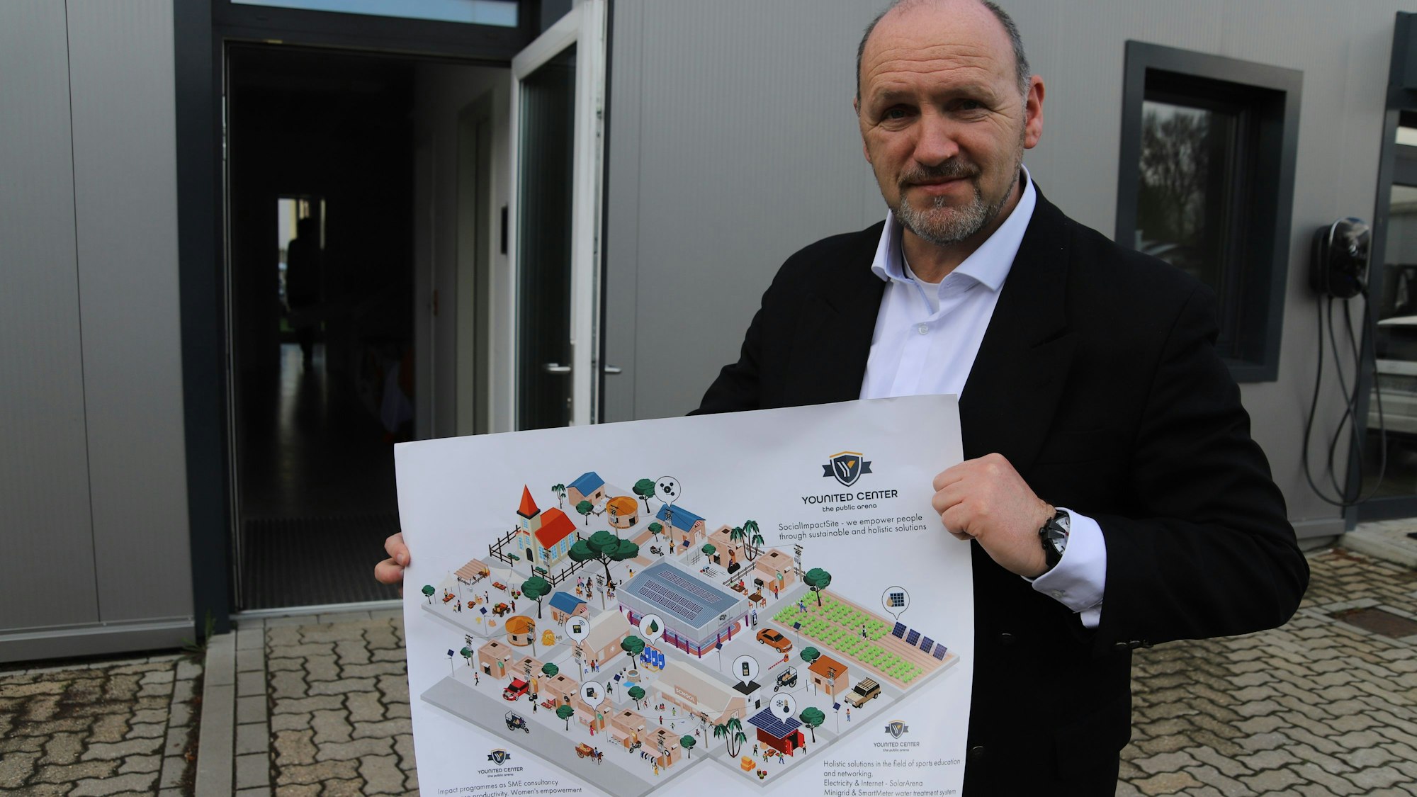 Es ist Jörg Jakobs zu sehen, der einen Plan in der Hand hält.