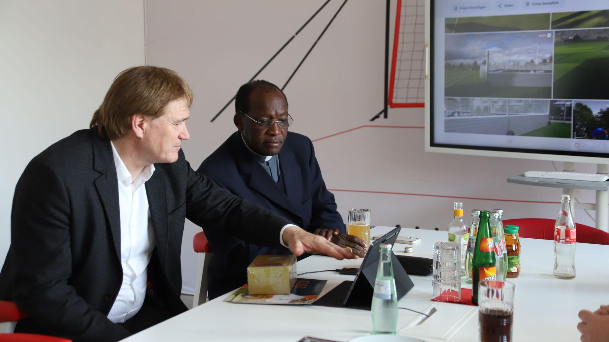 Es sind der Erzbischof Martin Kivuva Musonde und Ralf Esser zu sehen.