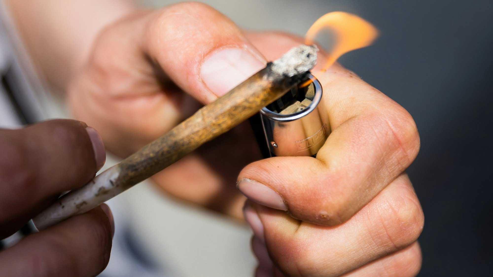 Ein Mann zündet einen Joint an.