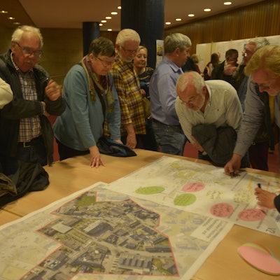 Bürger beraten bei der Bürgerbeteiligung zum Stadtentwicklungsprogramm Isek in einem Workshop über Pläne.