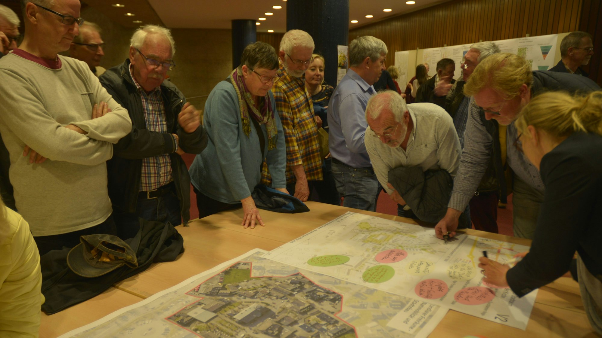 Es sind mehrere Lindlarer Bürger zu sehen, die um einen Tisch stehen und an Ideen arbeiten.