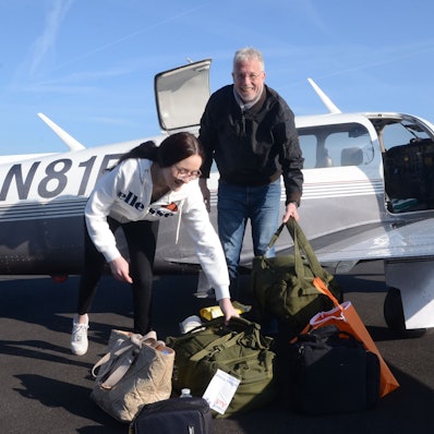 Es sind Lara Hehl und Ralph Wickenhöfer zu sehen, die auf dem Flugplatz stehen.