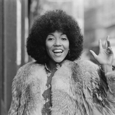 Die englische Sängerin, Songschreiberin und Gitarristin Linda Lewis winkt.