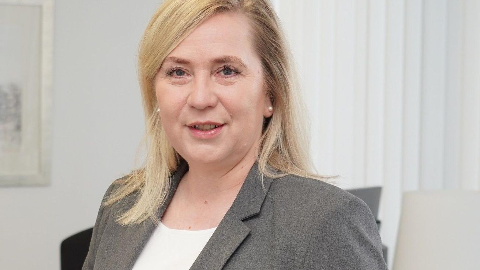 Auf dem Foto ist ein Portrait von Frechens Bürgermeisterin Susanne Stupp zu sehen, sie trägt ein weißes T-Shirt und ein graues Sakko.
