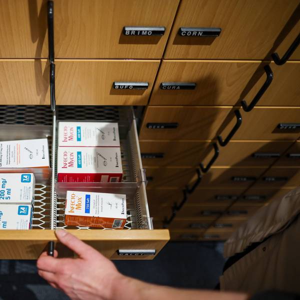 Eine Apothekerin öffnet ein Schubfach mit Antibiotikasäften für Kinder.