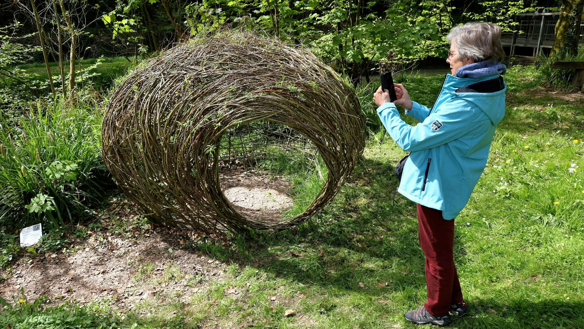 Eine Besucherin steht vor Kokon von Inge Lager.