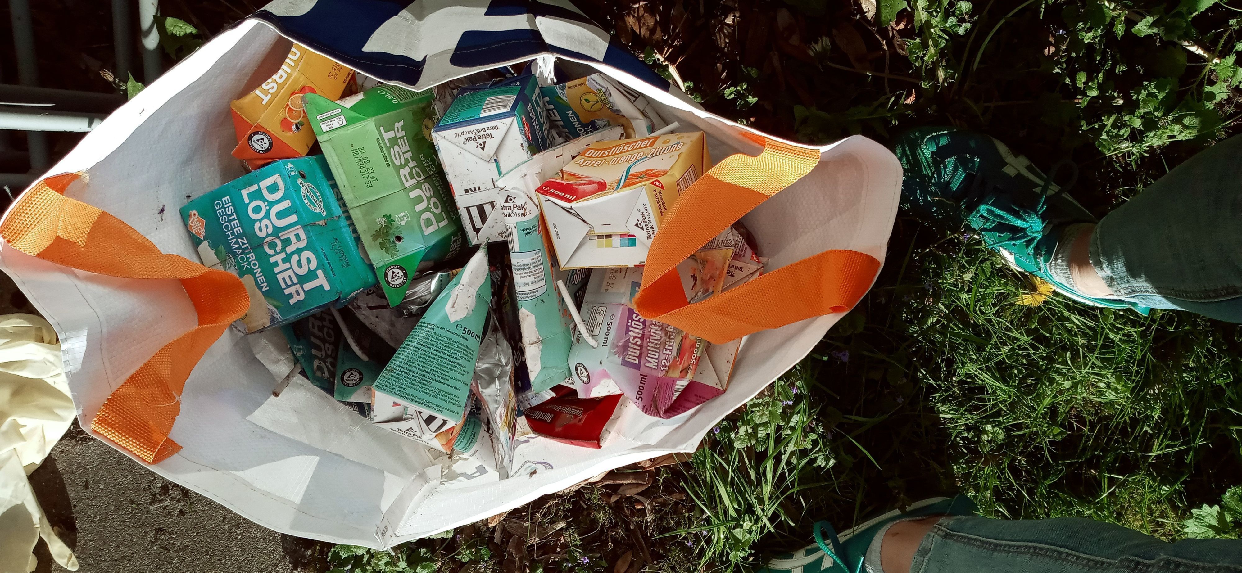 Leere Trinkpäckchenpackungen sind in einer Plastiktüte gesammelt.