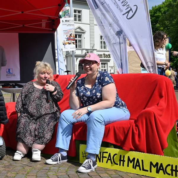 Aktion Inklusionsbeirat zum Protesttag zur Gleichstellung von Menschen mit Behinderung mit einer roten Couch.