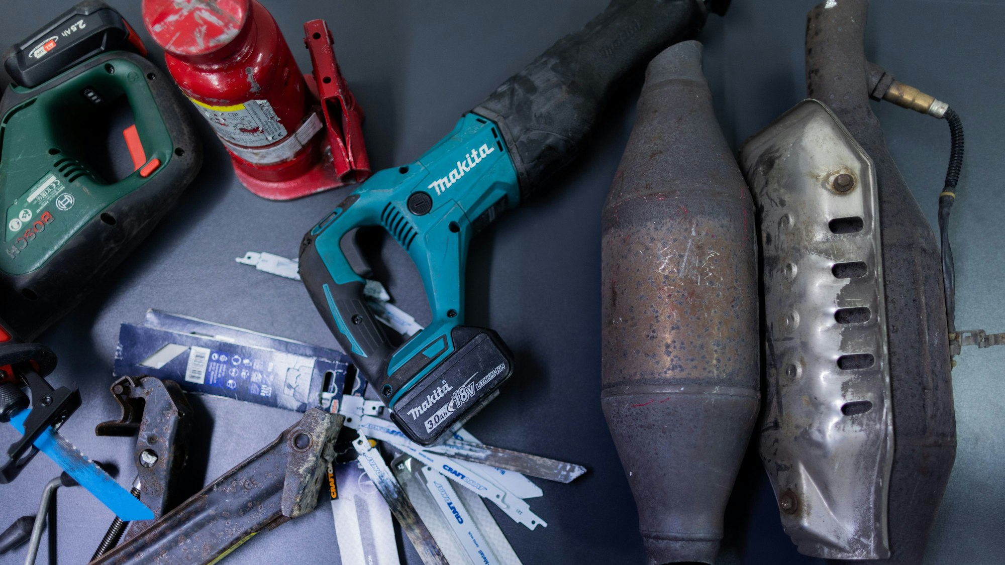 Gestohlene Katalysatoren von Autos und eine elektrische Säge liegen im Polizeipräsidium Düsseldorf auf einem Tisch.