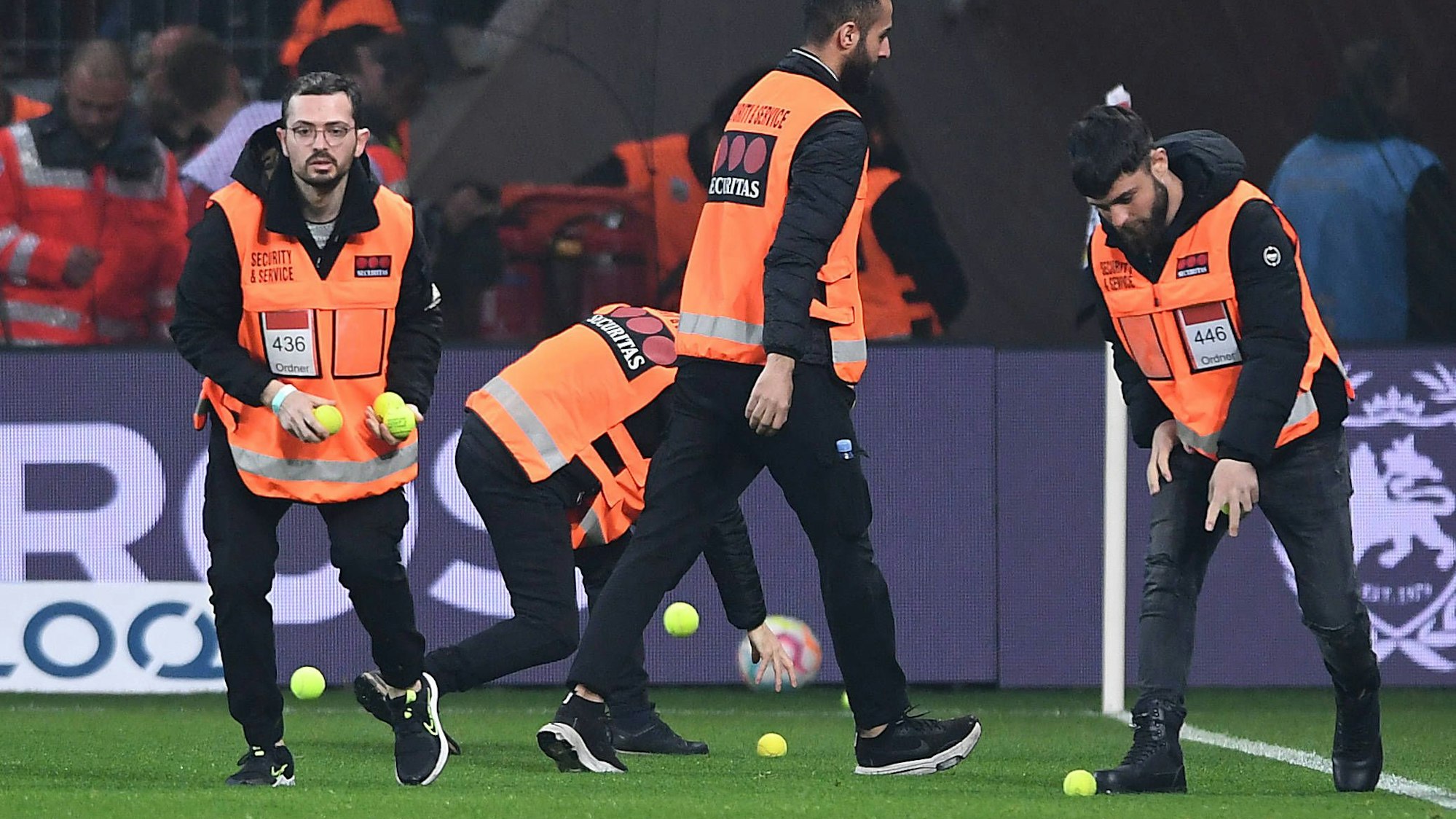Ordner sammeln Tennisbälle im Levrekusener Stadion ein.