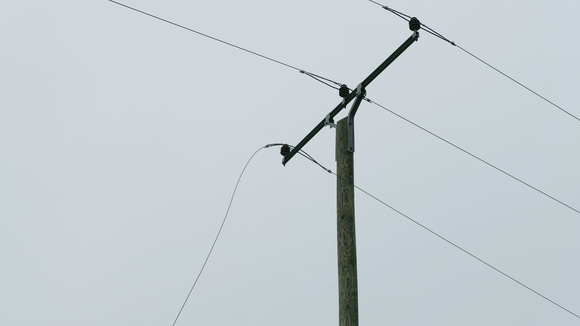 Ein Teil der abgerissenen Stromleitung. Ein Kabel hängt herab.