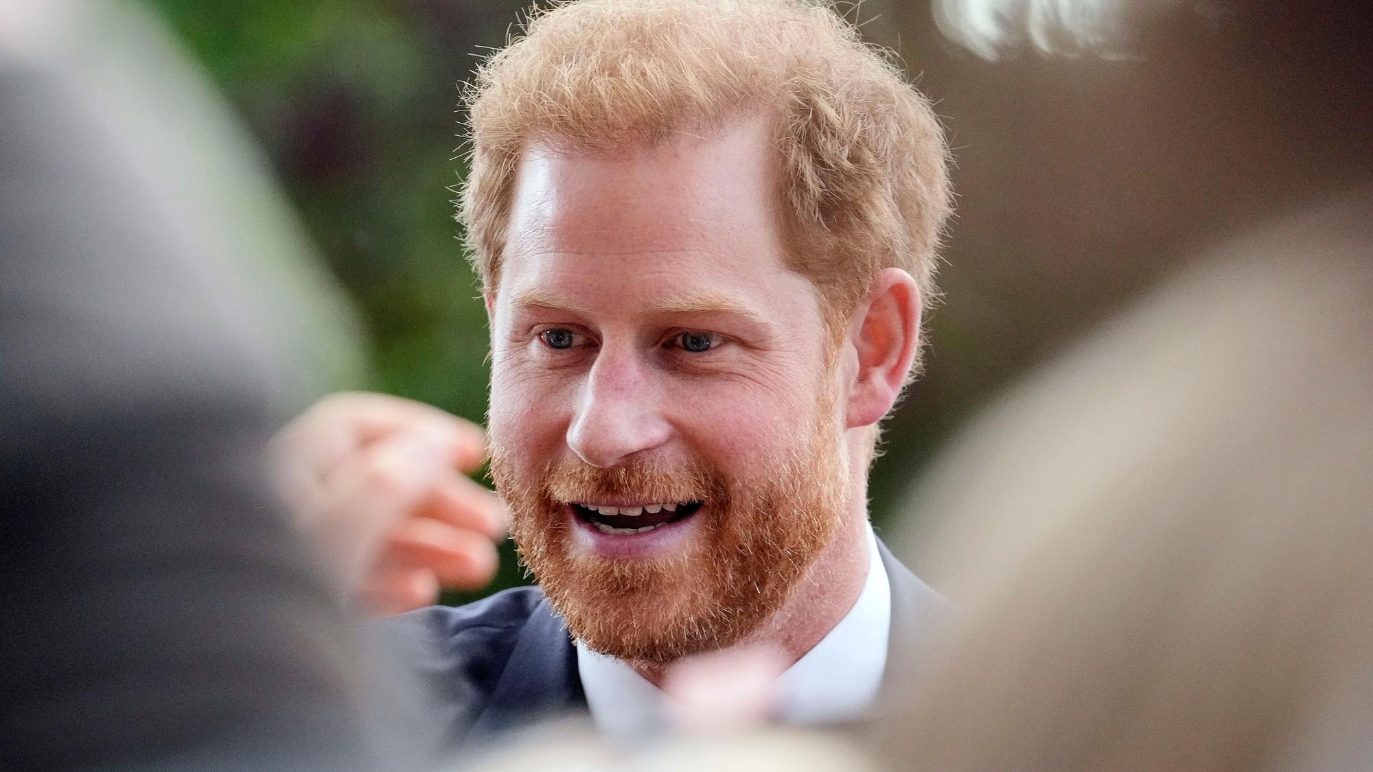 Der britische Prinz Harry, Herzog von Sussex, unterhält sich mit Menschen, nachdem er die Blumenarrangements zu Ehren der verstorbenen Königin Elizabeth II. vor Schloss Windsor besichtigt hat.