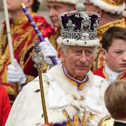 König Charles III. verlässt nach der Krönungszeremonie mit der Imperial State Crown, einem Zepter und dem Reichsapfel die Westminster Abbey.