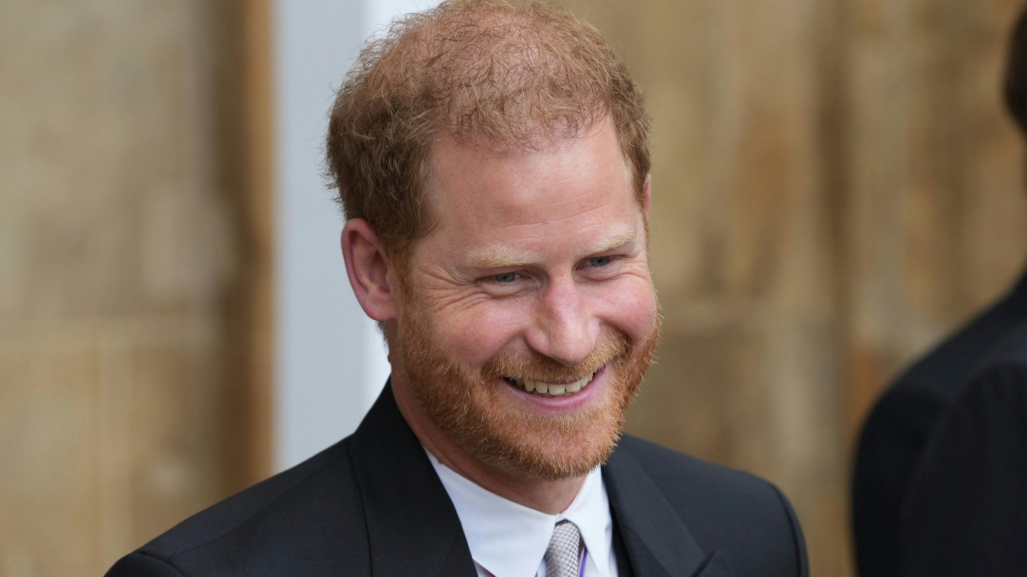 Prinz Harry, Herzog von Sussex, verlässt nach der Krönung von König Charles III. und Königin Camilla die Westminster Abbey und lächelt.