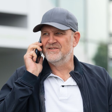 Jörg Schmadtke telefoniert als Sportdirektor des VfL Wolfsburg mit dem Handy