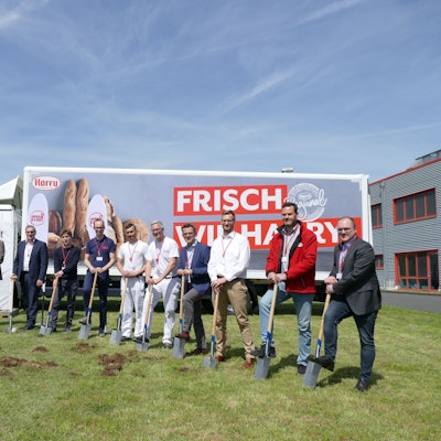 Wichtige Menschen von Harry Brot beim Spatenstich, im Hintergrund sieht man einen Bagger und einen LKW mit dem Firmen-Logo.