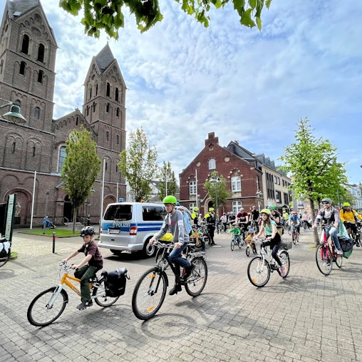 Kinder und Erwachsene fahren auf Fahrrädern durch Leverkusen.