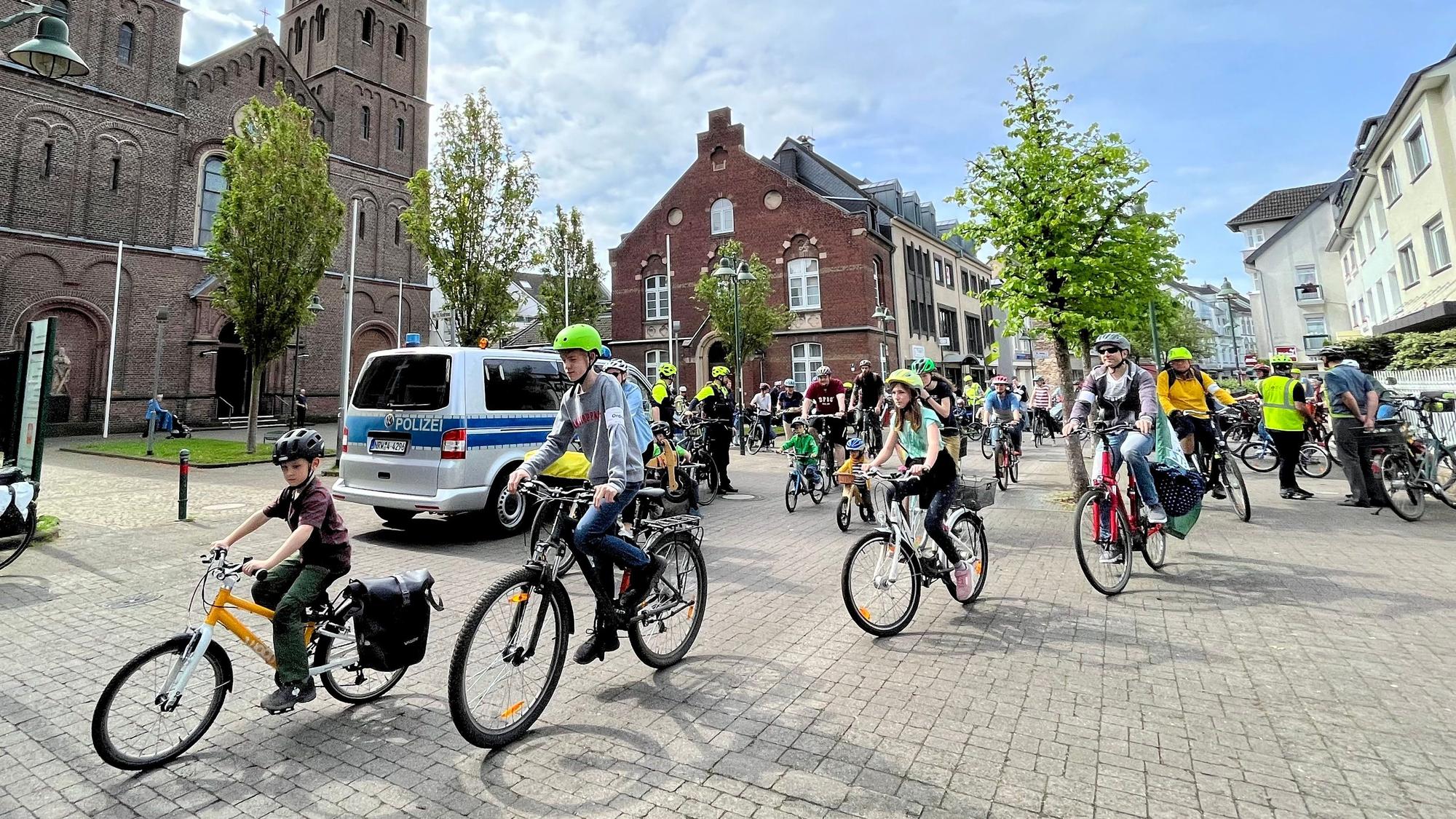 Kinder und Erwachsene fahren auf Fahrrädern durch Leverkusen.