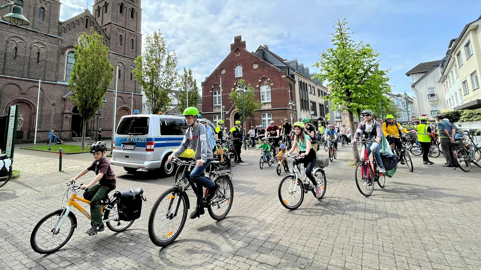 Kinder und Erwachsene fahren auf Fahrrädern durch Leverkusen.