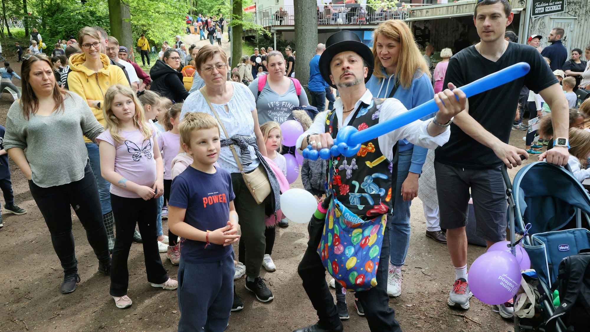 Ballonkünstler mit Kindern und Eltern.