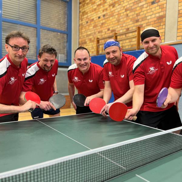 Sechs Tischtennisspieler posieren mit Schläger an einer Platte.