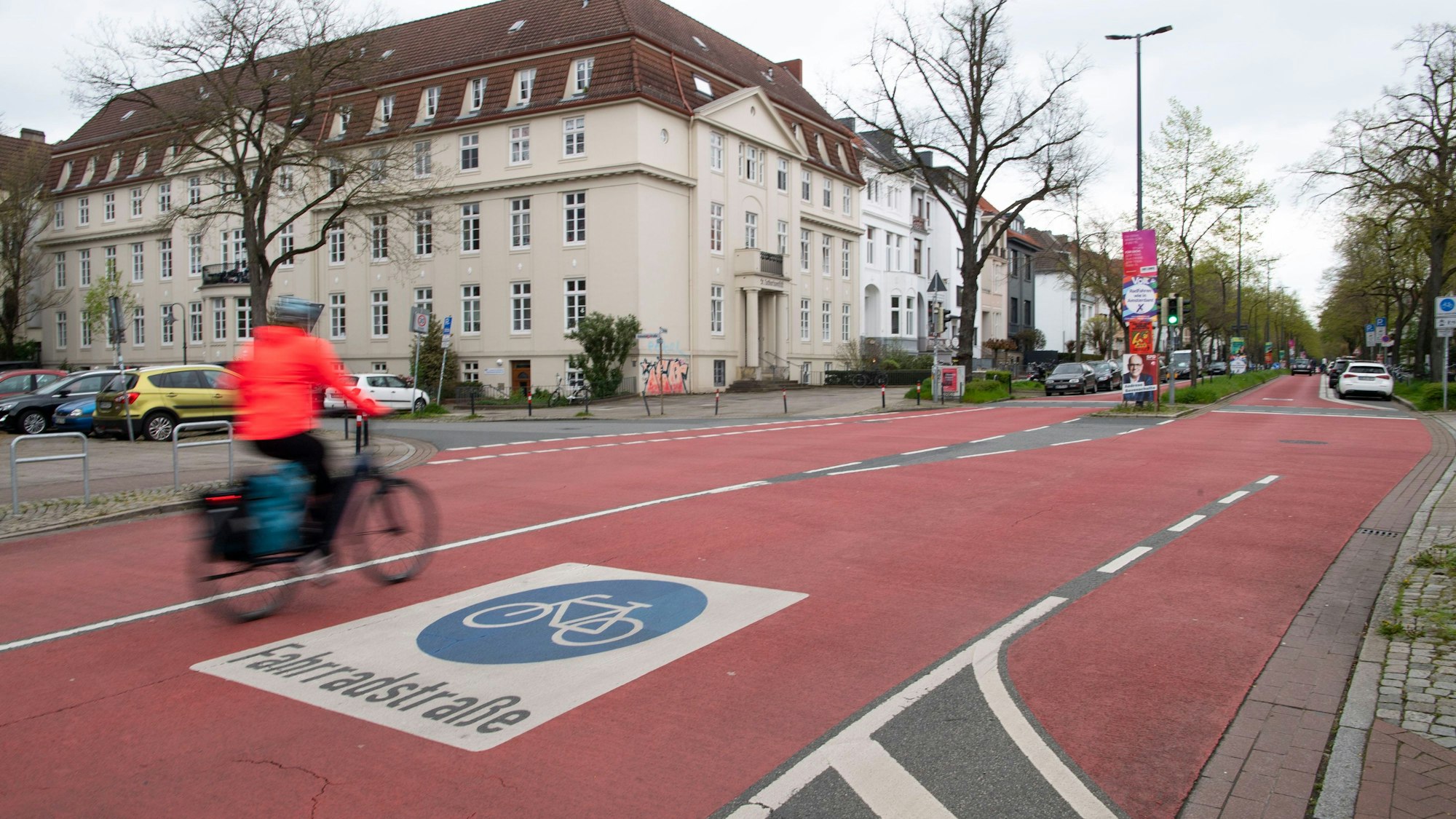 Eine Radfahrerin in der Bremer Innenstadt fährt über einen breiten, rot markierten Radweg mit der Aufschrift „Fahrradstraße“.