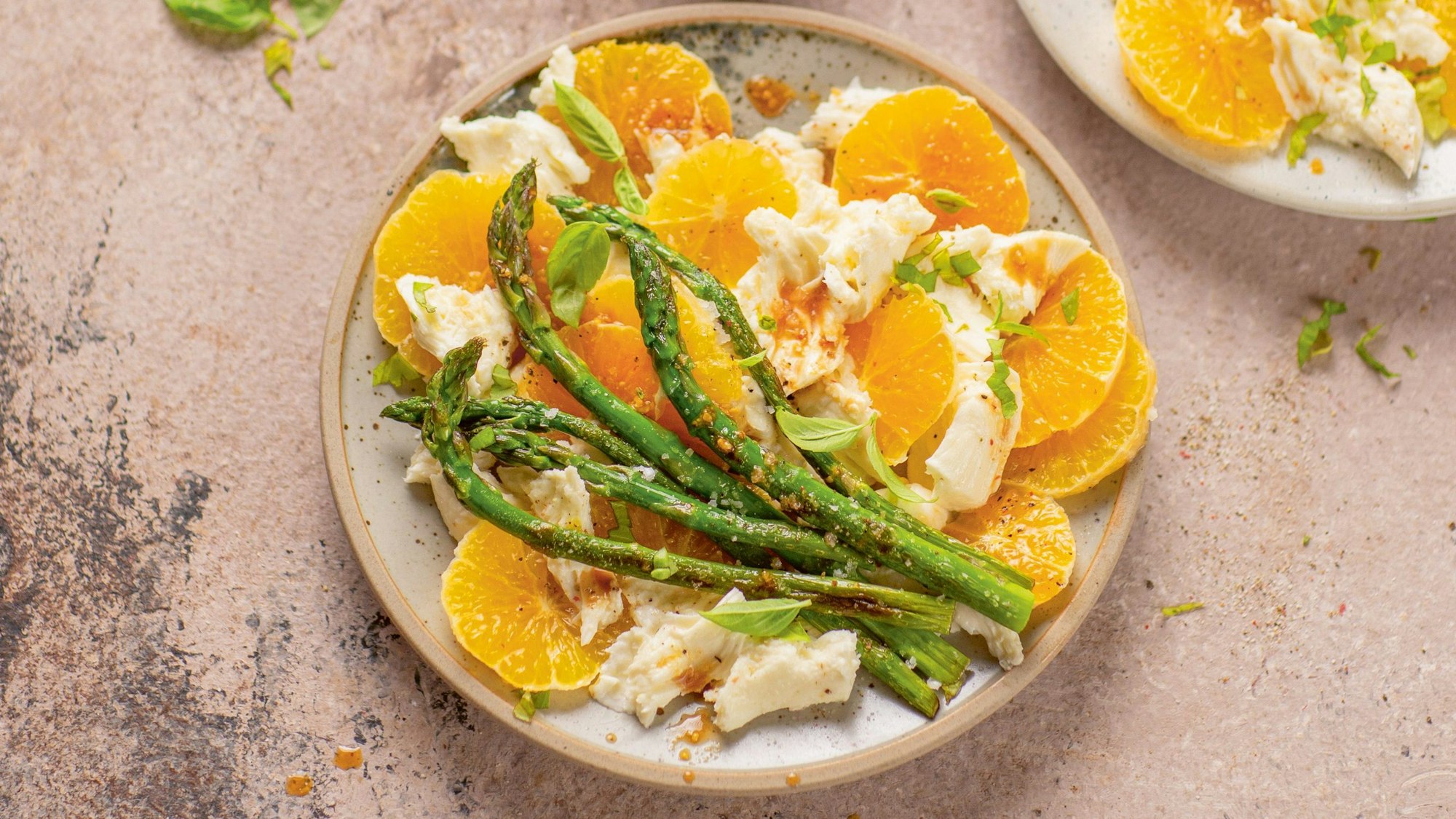 Orangenscheiben, Mozzarella und grüner Spargel angerichtet auf einem Teller