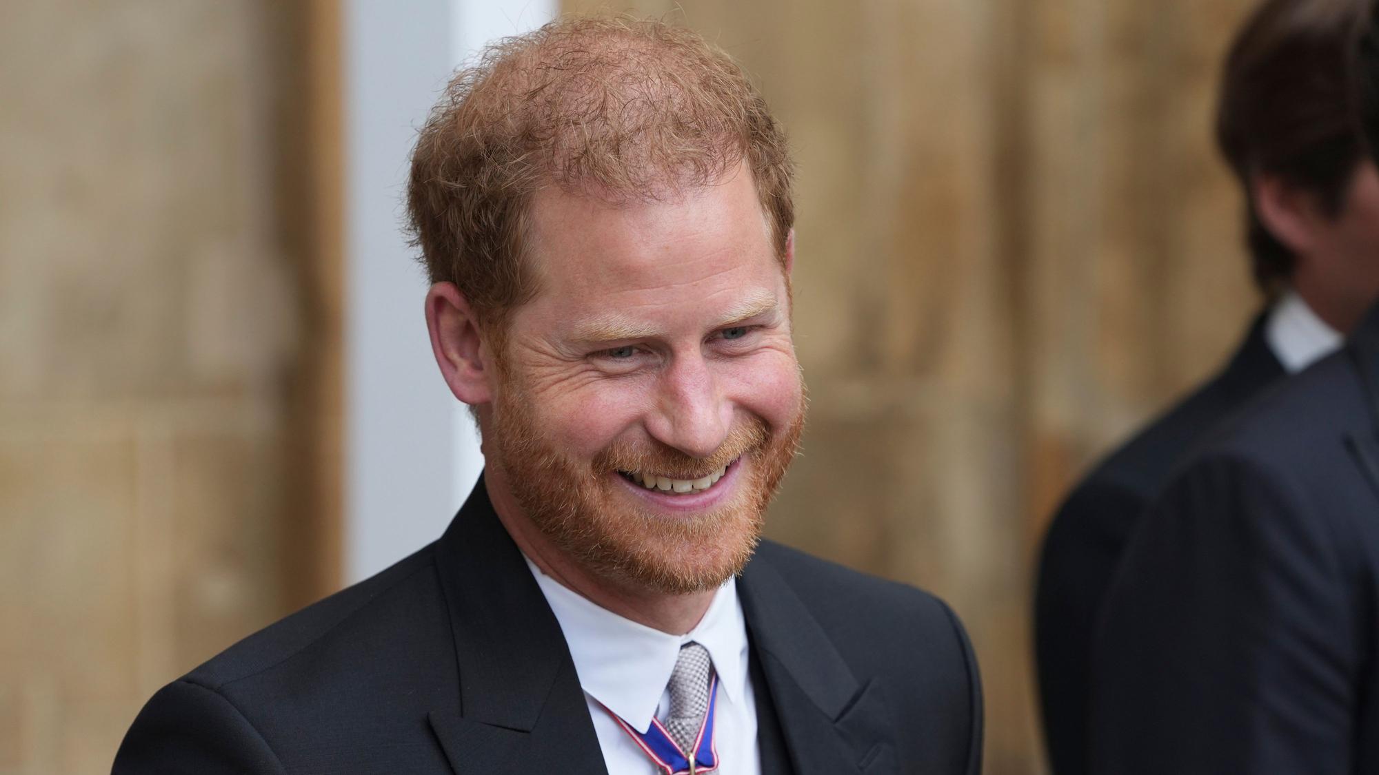 Prinz Harry, Herzog von Sussex, verlässt lächelnd die Westminster Abbey nach der Krönung von König Charles III. und Königin Camilla.