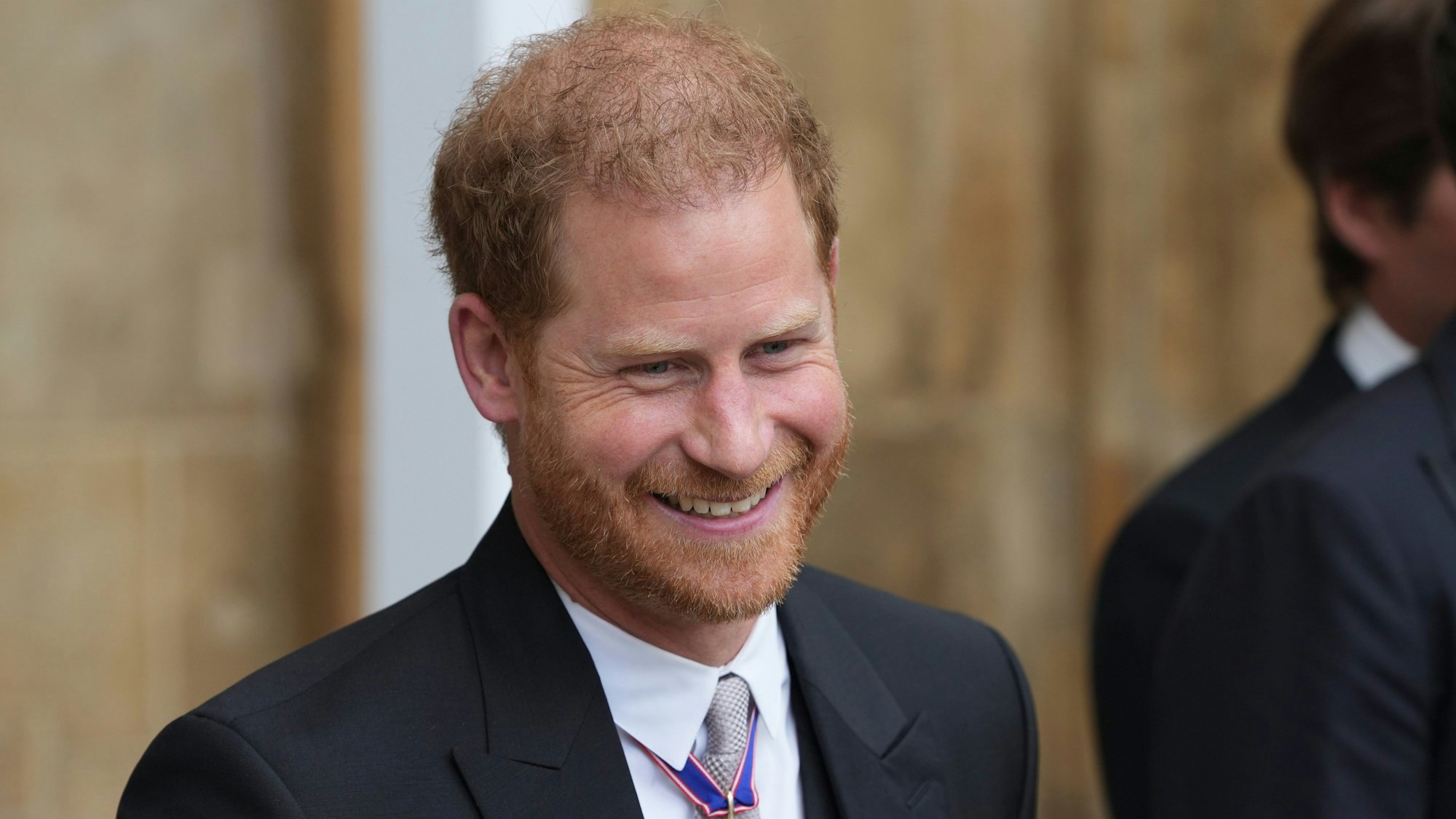 Prinz Harry, Herzog von Sussex, verlässt nach der Krönung von König Charles III. und Königin Camilla die Westminster Abbey und lächelt.