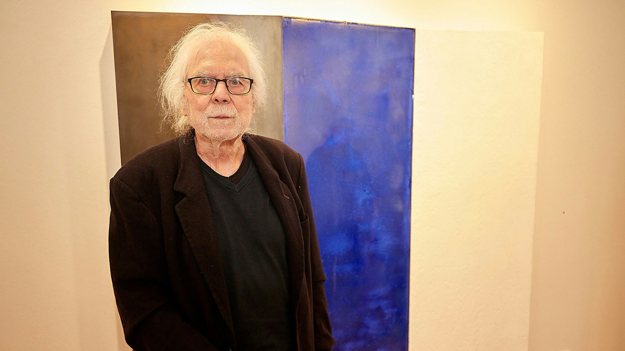 Der Künstler Paul Dieter Krämer steht vor einem seiner Werke.