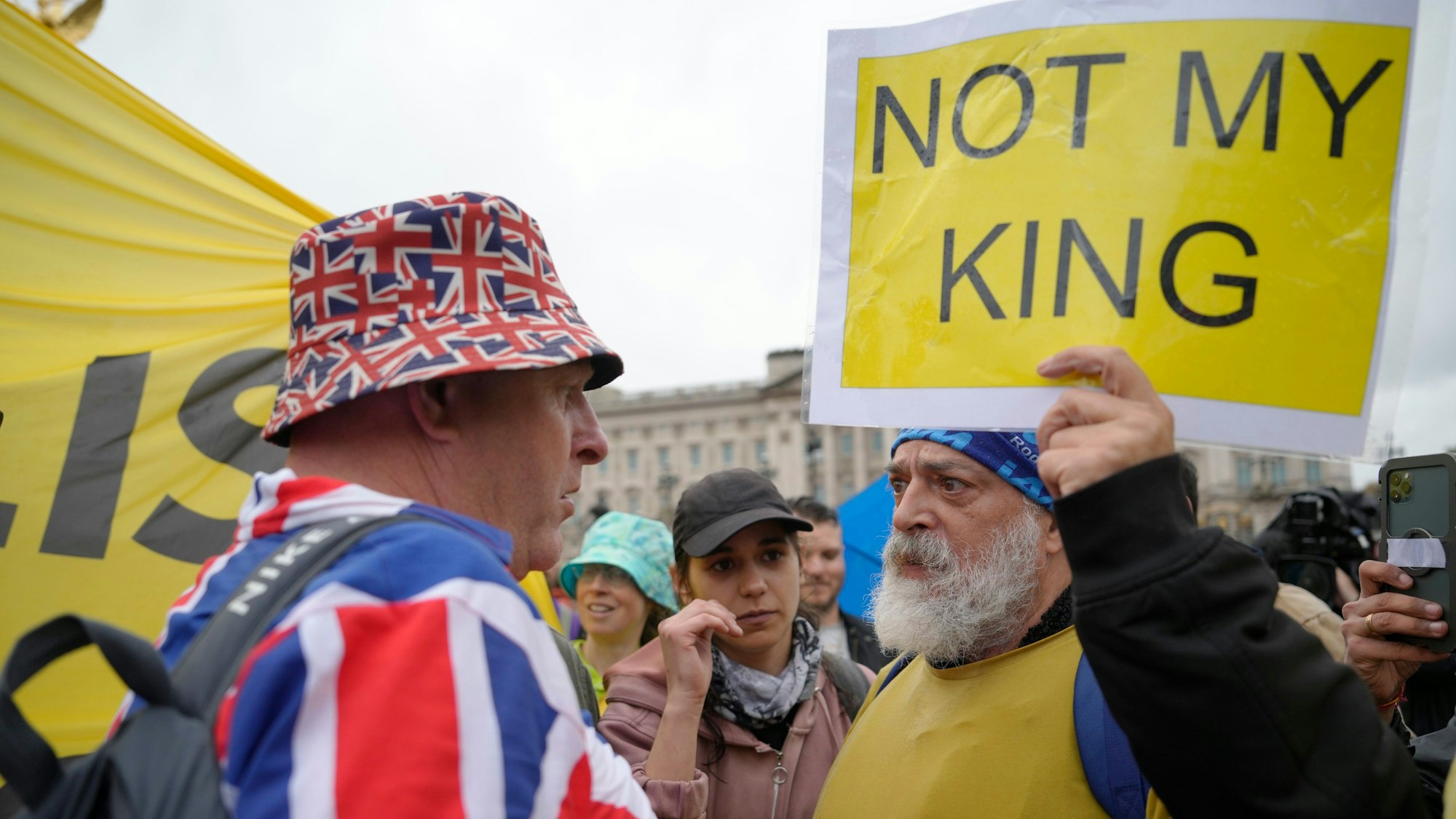Ein Anti-Monarchie-Demonstrant (r.) spricht mit einem Monarchie-Befürworter in der Nähe des Buckingham-Palastes. Gegen die Krönung von König Charles III. haben Menschen in mehreren britischen Städten demonstriert.