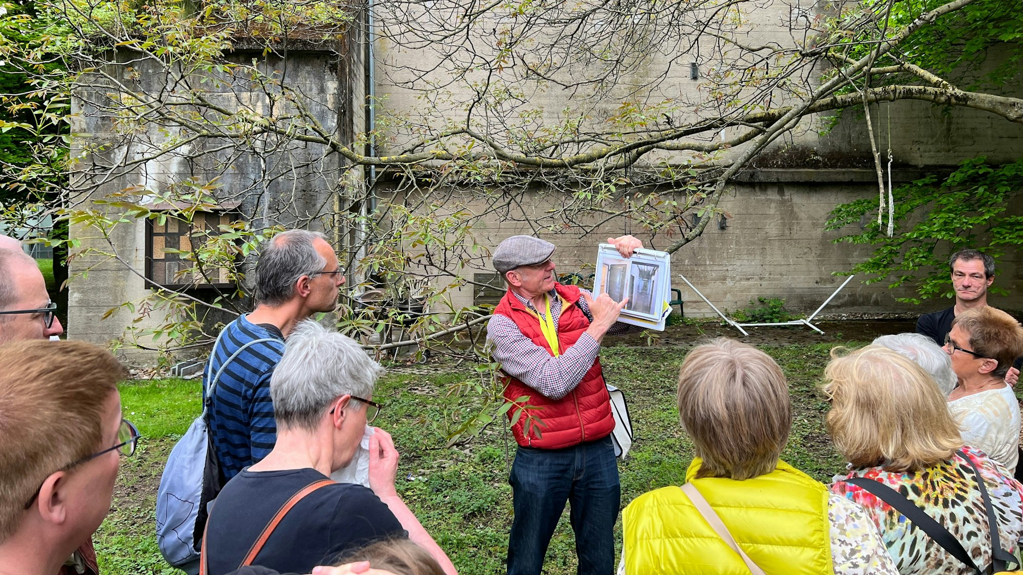 Gastführer Roland Schaper zeigt den Gästen alte Fotos.