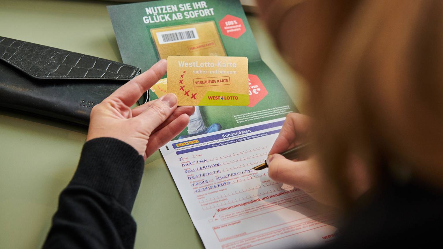 Frau hält die Westlotto Karte in der Hand.