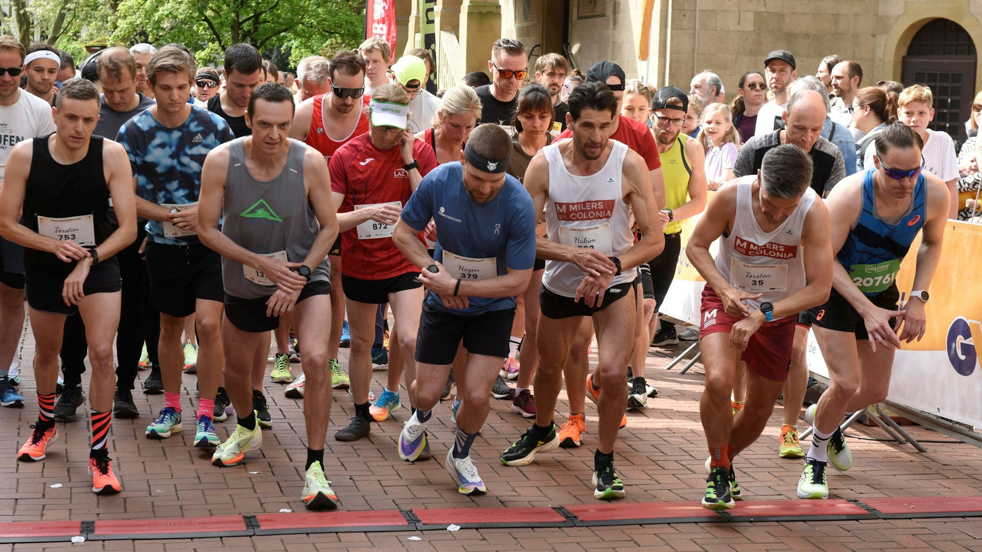 Mehrere Läufer stehen an der Startlinie.