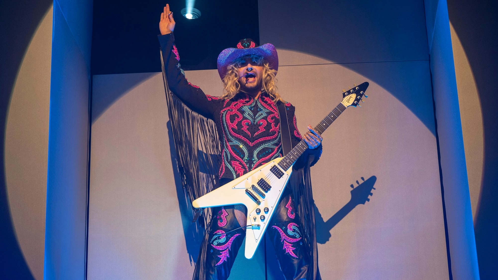 Bill Kaulitz mit Cowboyhut und Metalgitarre auf der Bühne im Kölner E-Werk.
