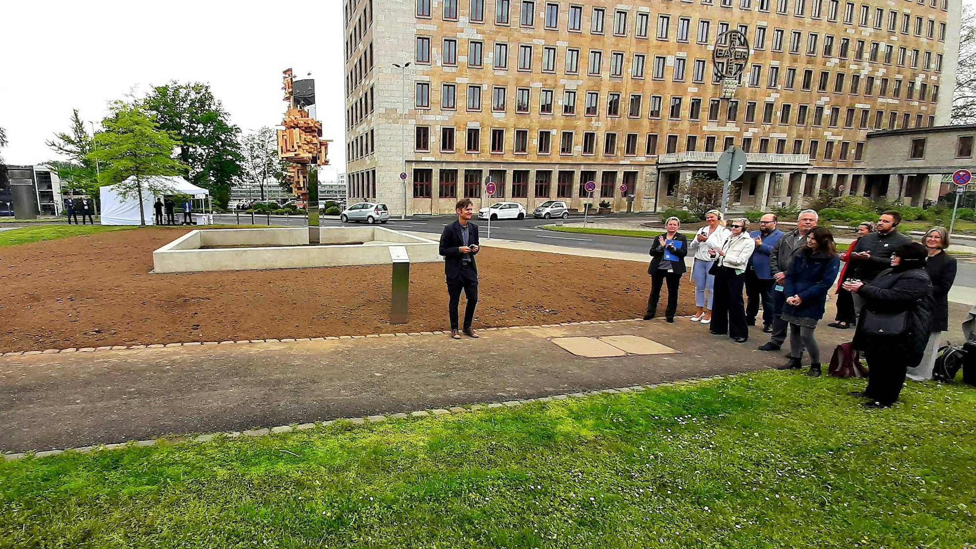 Der finnische Künstler Jussi Ängeslevä spricht bei der Eröffnung des von ihm gestalteten Kunstwerkes und Erinnerungsortes für die Zwangsarbeitenden der Bayer AG.