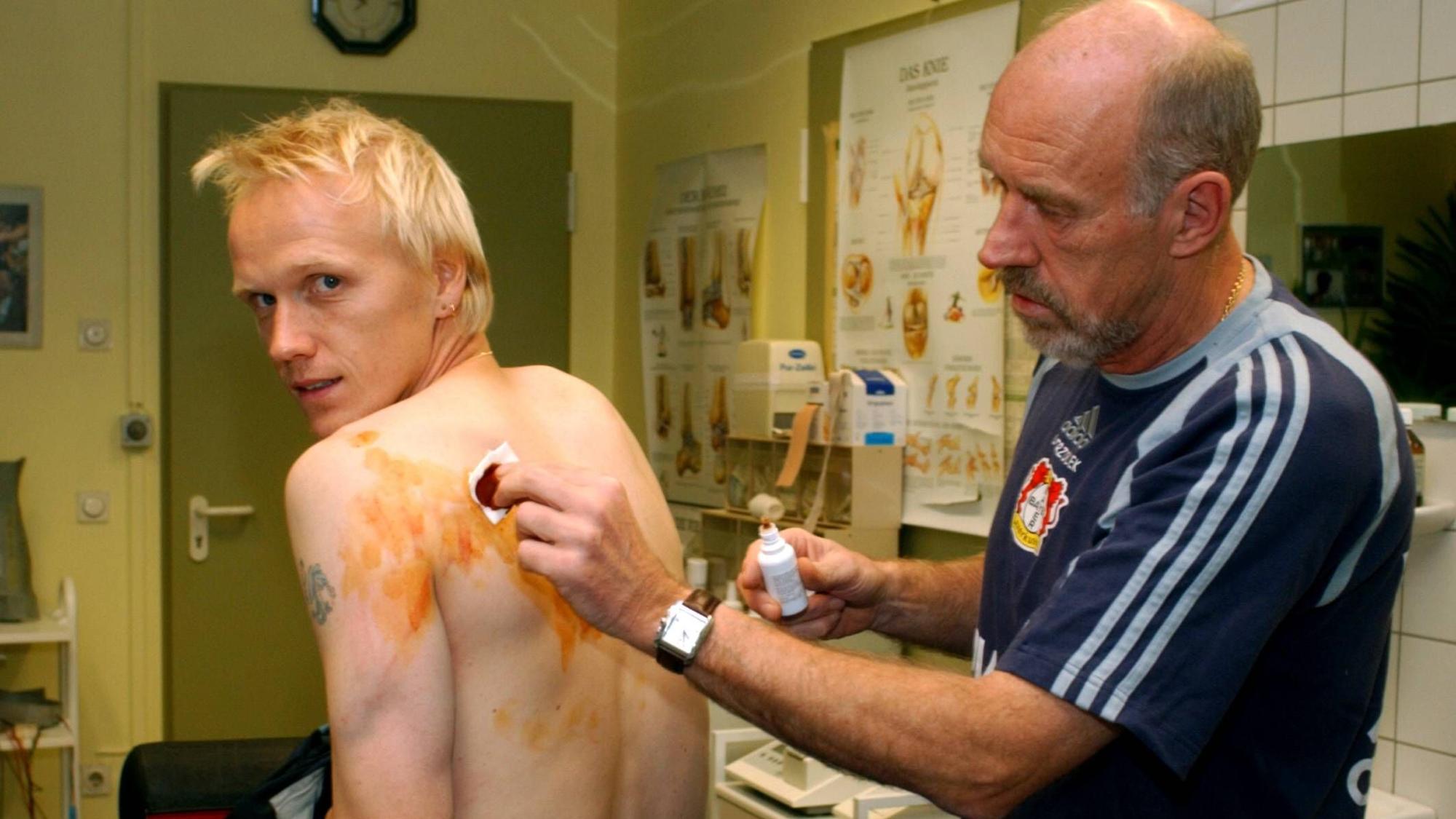 Leverkusens Physiotherapeut Dieter Trzolek behandelt die Rückenblessuren von Carsten Ramelow. Sie sind das Ergebnis von Tottis Tritt.