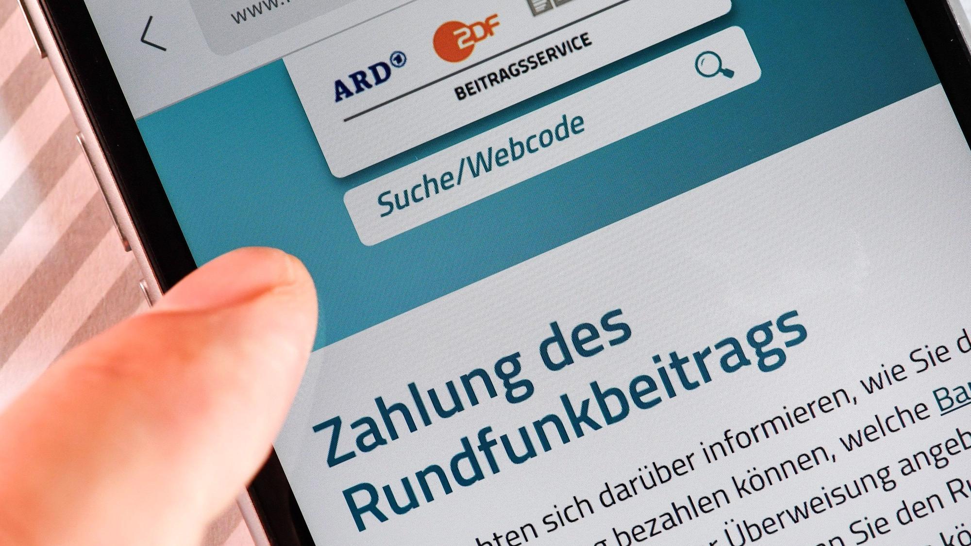 Auf einem Smartphone ist eine Website zur Information über die Zahlung des Rundfunkbeitrags aufgerufen.