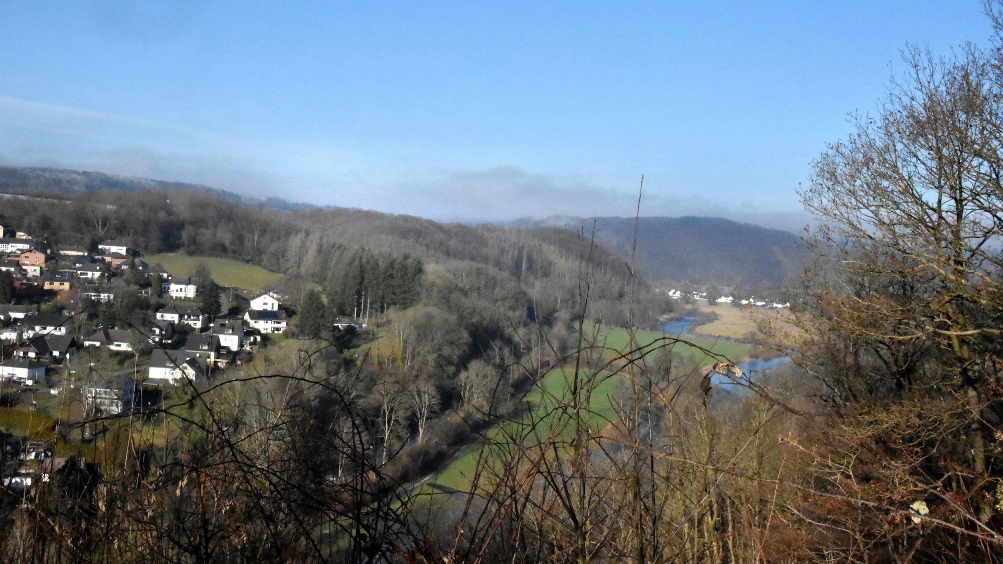 Ein Tal mit Bäumen und Häusern.