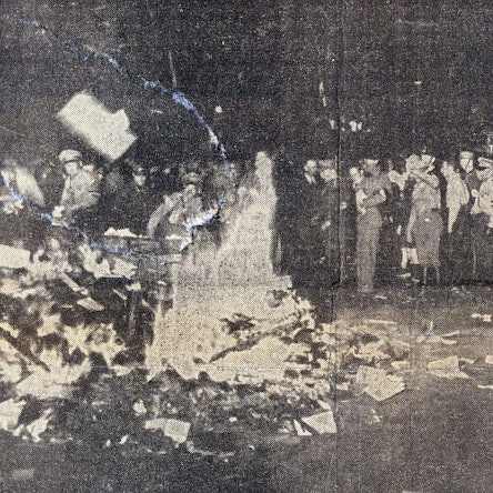 Auf dem schwarz-weiß-Foto ist ein brennender Scheiterhaufen zu sehen, zu seinen Füßen liegen ein paar unverberbrannte Bücher. Im Hintergrund einige Menschen, darunter auch einige in Uniform.